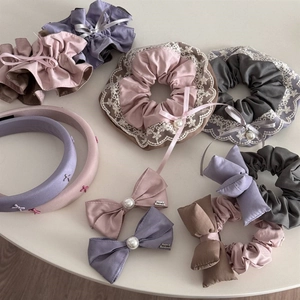 Detailed shot of Morandi toned lace scrunchies and headbands with delicate pearl accents