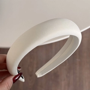 Detailed close-up of cream-white padded sponge headband with fine diagonal twill fabric texture