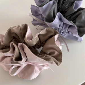 Close-up of pink and purple satin lace hair scrunchies with elegant ribbon bow details