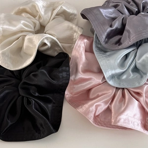 Macro shot of assorted premium silky satin scrunchies in minimalist solid vintage colors
