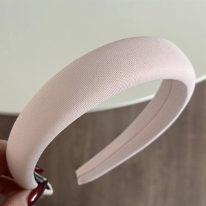 Close-up of pink sponge headband showing the ribbed fabric texture and soft rounded design