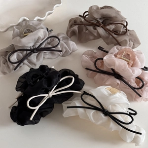 Vue détaillée de pinces à cheveux avec volants en organza plissés et nœuds élégants