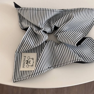 Detailed shot of black and white striped scrunchie with fashion bear fabric label