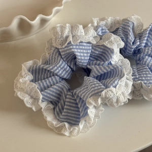 Détail de chouchous à rayures bleues avec dentelle blanche sur un plateau