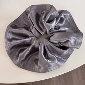 Detail of silver satin scrunchie showing premium glossy silk texture and stitching