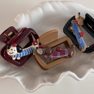 Detailed view of three cute cartoon dachshund hair claws in red, khaki, and black colors