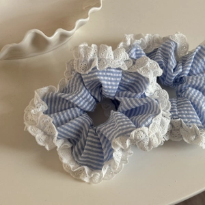 Détail de chouchous à rayures bleues avec dentelle blanche et broderie florale