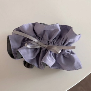 Close-up of light purple satin scrunchie with lace trim and a grey ribbon bow detail
