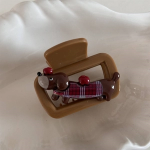 Detailed view of a brown puppy claw clip with a red checkered dachshund design