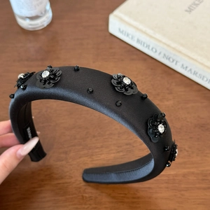 Elegant black satin headband with sequin flower patterns and sparkling rhinestone details