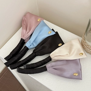 Five-piece set of satin banana hair clips in pastel colors with gold metal logo accents