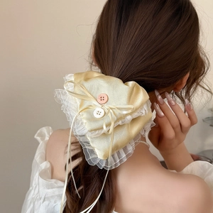Detailed back view of a satin heart hair tie with white lace trim and ribbon bow