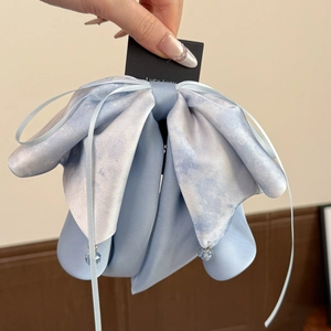 Détail de la pince à cheveux noeud en soie bleue avec pendentifs élégants en cristal bleu