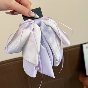 Détail du nœud en satin lavande dégradé avec des glands de perles en cristal