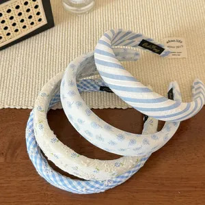 Detailed top view of blue striped and floral fabric headbands on wooden table