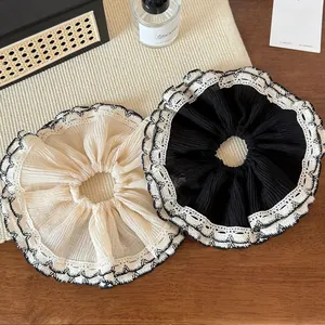 Gros plan de chouchous élégants bordés de dentelle en crème et noir sur une surface