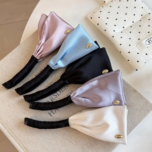 Detail of five satin hair clips in pastel colors with elegant golden metal buckles