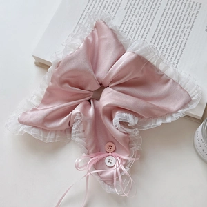 Detailed macro view of pink satin scrunchie with white lace edges and a delicate ribbon bow