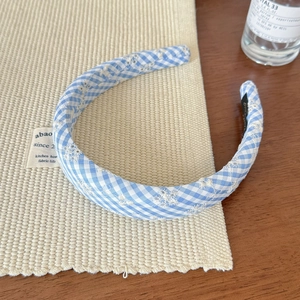 Detail of blue gingham headband featuring delicate white floral embroidery and anti-slip lining