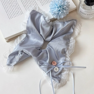 Close-up of light blue satin hair tie with white lace trim and bowknot detail