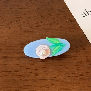 Detail of floral acetate hair clip with pink tulip relief and white pearl accent