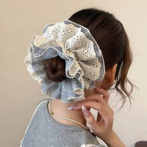 Chouchou oversize avec fleurs et dentelle porté sur un chignon vue de dos élégante
