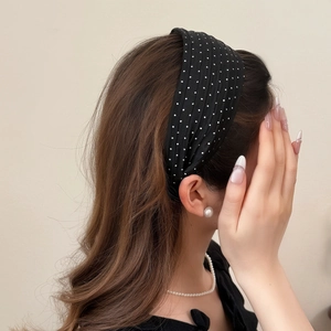 Polka dot wide headband in black fabric worn by a model for a fresh summer look