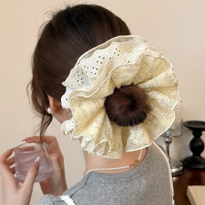 Détail d'un chouchou floral à quatre couches avec bords en dentelle sur un chignon