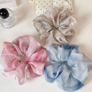 Three gradient organza scrunchies in pink, blue, and grey with a pearlescent finish