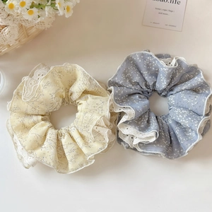 Détail de chouchous à fleurs en dentelle jaune et bleu-gris avec des bords blancs fins
