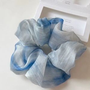 Macro shot of blue and white tie-dye scrunchie in lightweight organza with soft texture