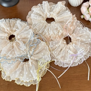 Details bunter Polka-Dot-Spitzen-Haargummis mit feinen Schleifen auf Holzuntergrund