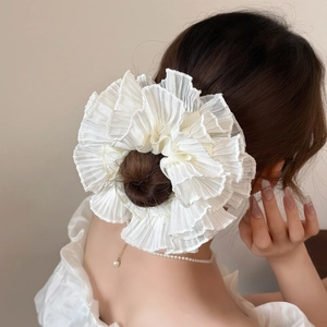 Elegant oversized white ruffled scrunchie in organza on a low bun hairstyle
