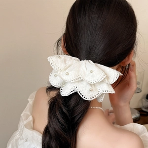 Elegant large white lace hair scrunchie with pearls worn on dark curly hair