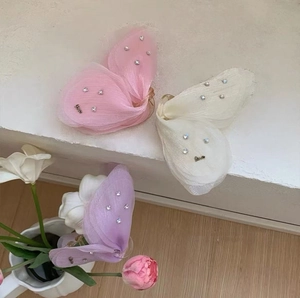 Three tulle butterfly hair claws in pink, cream, and purple with rhinestones and Love charms
