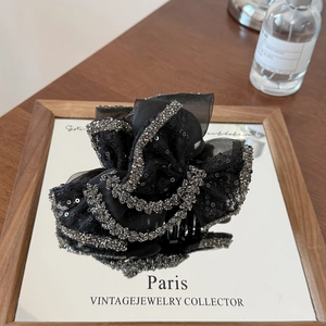 Macro detail of elegant black mesh bow hair claw clip with sparkling silver rhinestones