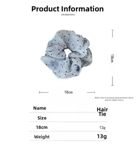 Detail view of 18cm light blue mesh scrunchie with black polka dots and size measurements