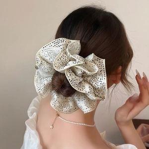 Elegant French style cream scrunchie with black polka dots for graceful hair styling