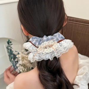 Blue plaid ballet-style scrunchie with layered lace trim and a bow on a model ponytail