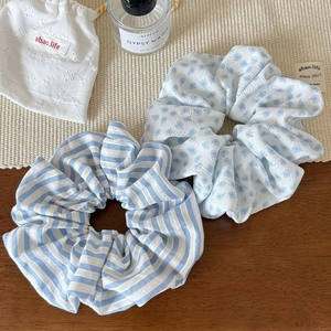 Lot de chouchous à rayures bleues et motifs floraux posés sur une table en bois