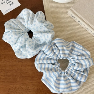 Détail de chouchous à fleurs et rayures bleues sur un fond en bois rustique