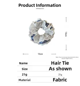 Detail showing oversized 16cm houndstooth scrunchie with layered white lace edges