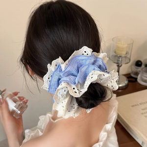 Lace layered blue gingham scrunchie shown in a stylish hairstyle for women