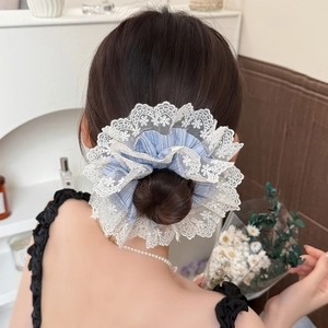 Chouchou rayé bleu surdimensionné avec bord en dentelle porté sur un chignon