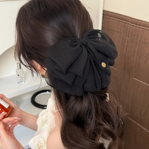 Elegant large black layered chiffon bow hair clip with gold logo detail on back of head