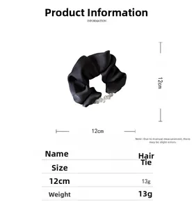Detail view of 12cm black satin scrunchie with crystal beads and smooth texture