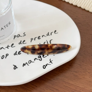 Détail macro d'une barrette en acétate écaille de tortue avec lettrage élégant