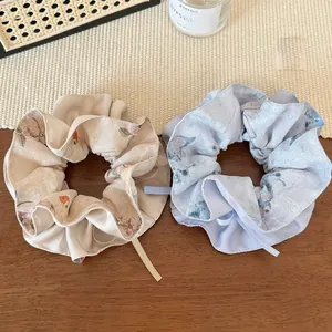 Détail de chouchous en mousseline à motifs floraux et papillons avec rubans élégants