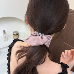 Elegant satin hair scrunchie in dusty pink with crystal beads shown on a ponytail