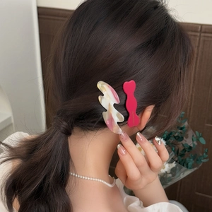 Irregular wavy acetate hair clips in pink marble and rose finish for elegant styling